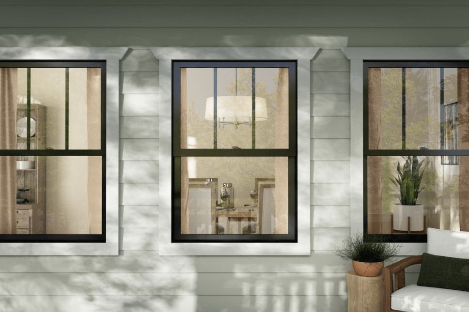 Shaded patio of a home with three similar black windows.