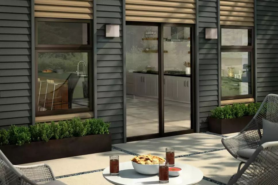Modern back patio with picture windows and black sliding patio doors.